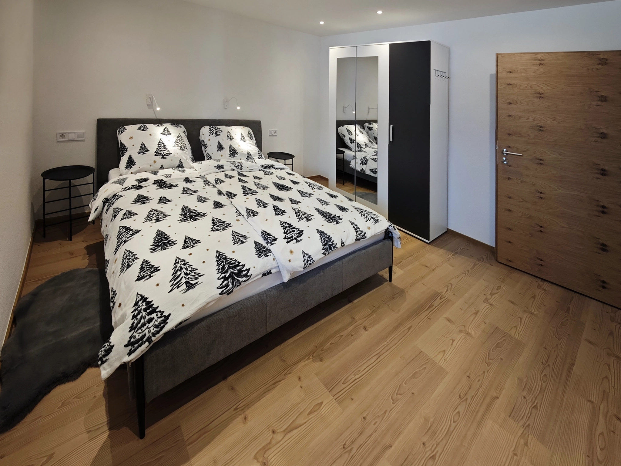Ložnice s manželskou postelí a velkou šatní skříní v Schwarm Haus Apartment