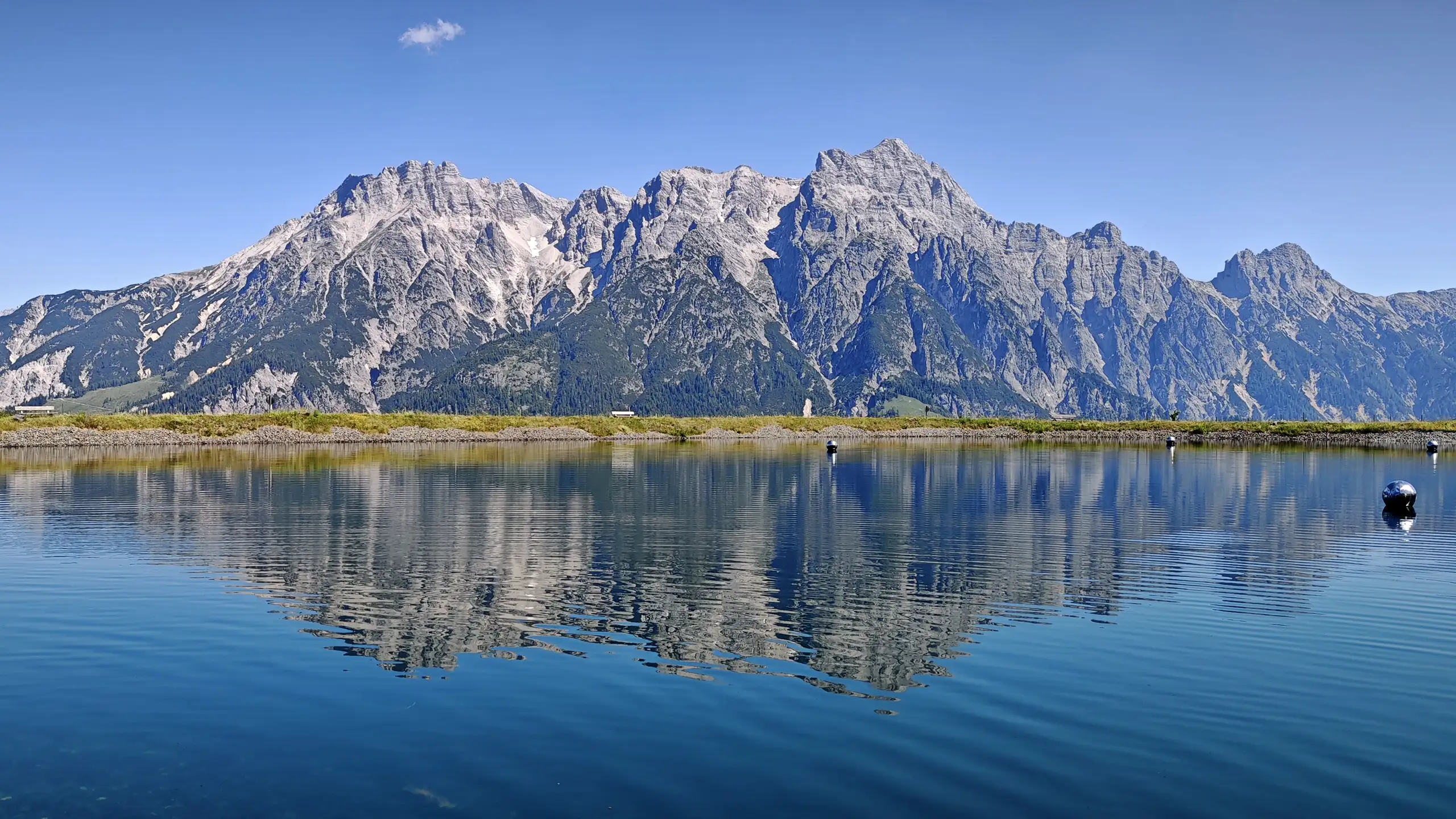 Mountain lake panorama in Fieberbrunn with alpine peaks reflected in the water